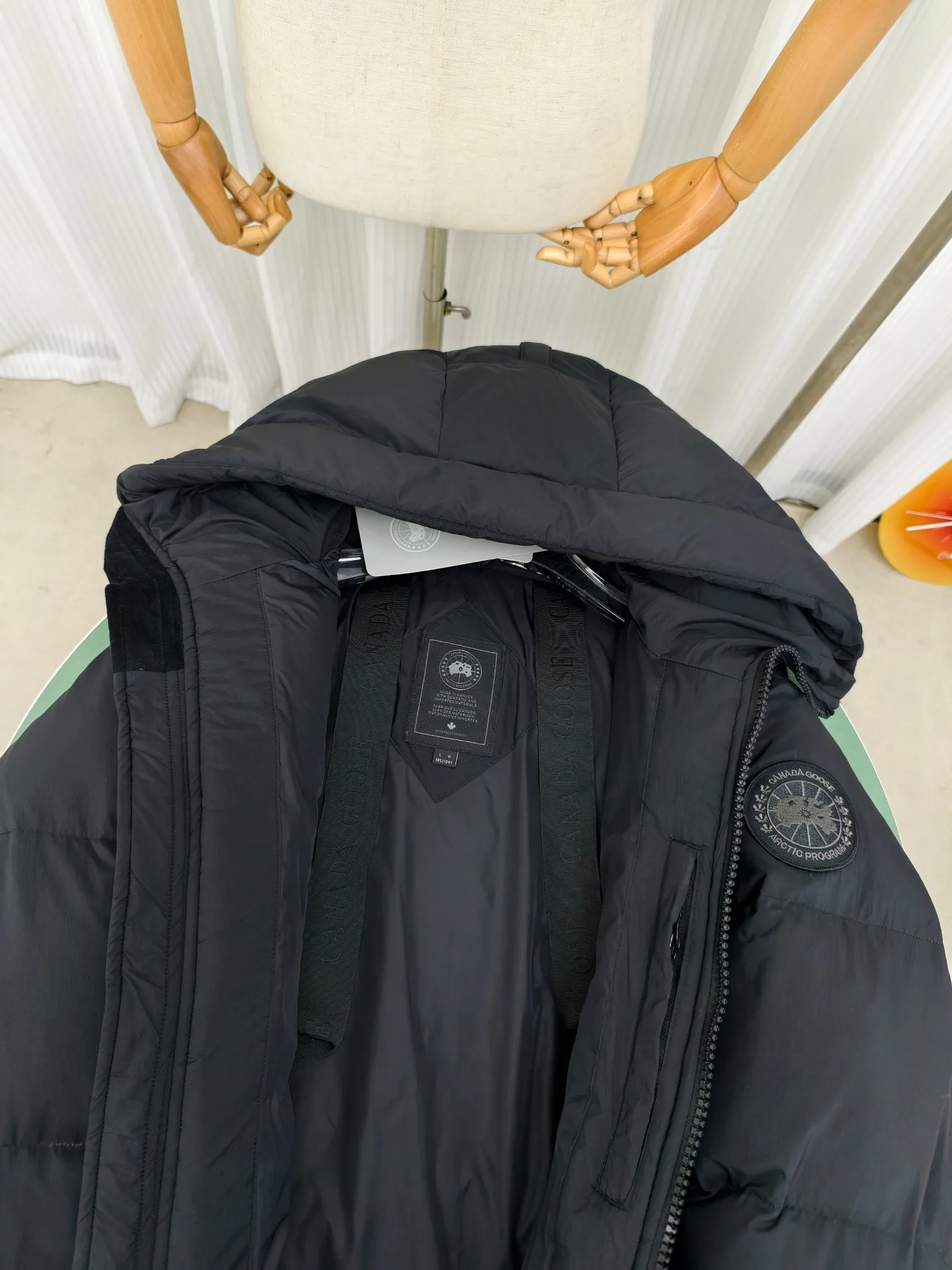 P940 Canada Goose Lawrence Down Jacket The Lawrence Down Jacket provides essential protection for everyday adventures and is made from sustainable Enduraluxe fabric with a durable soft touch. It features a quilted body, an adjustable down hood and a longer hem. Adjustable, down-filled, communicated hood. Two-way center front zipper increases range of motion and ventilation. The chin-protecting suede knit stand-up collar is soft and extra-comfortable. Inset rib-knit cuffs for added comfort and locked in heat. CORDURAD piping at the cuffs hem and reflective double-stripe grip tape at the back. Internal shoulder strap Color: black with red label black with black label azure blue Size: XS-2XL